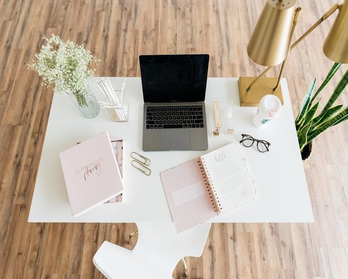 A clean workspace with a notebook and a plant